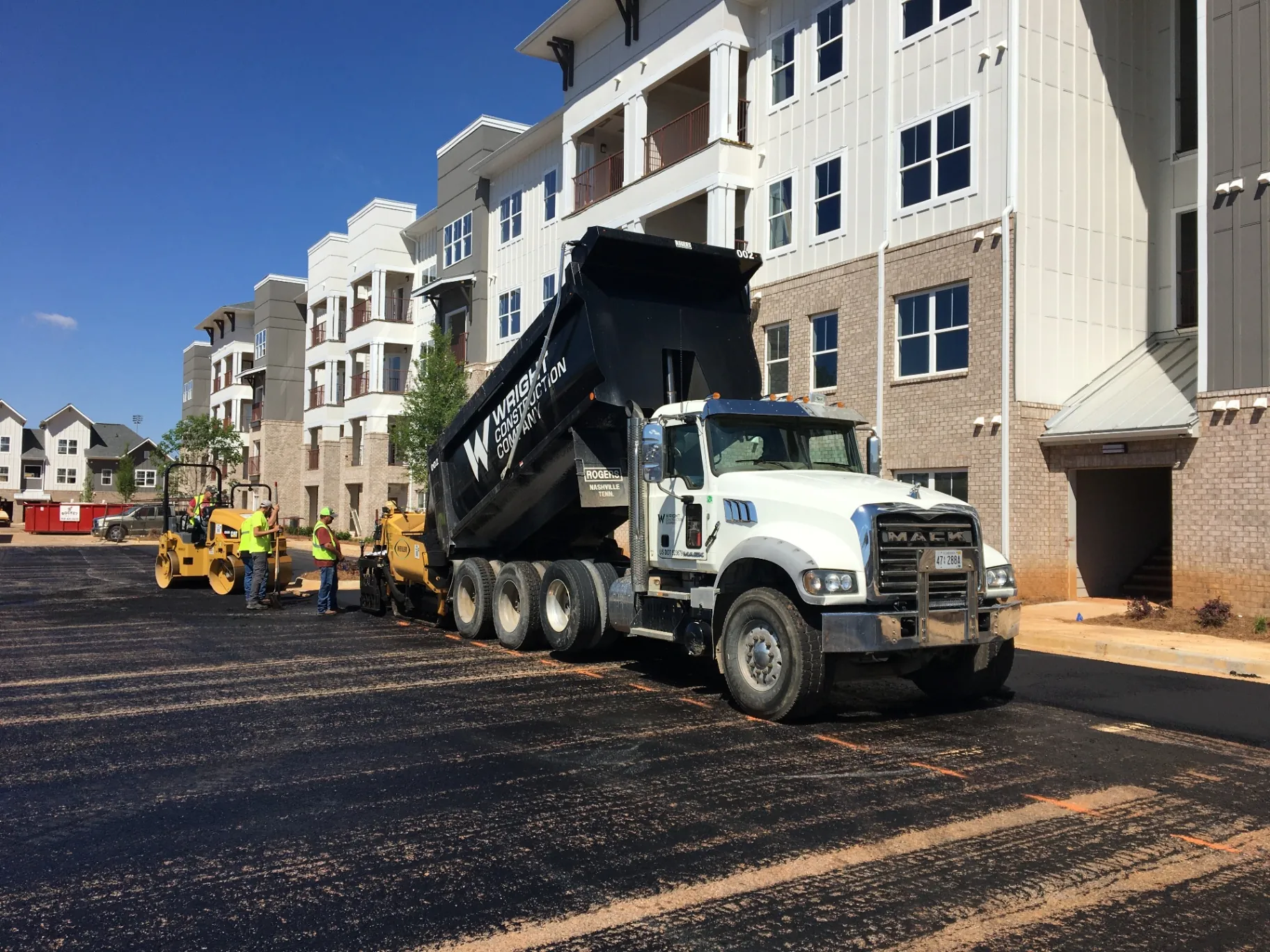 Project One Contracting paving crew laying fresh asphalt at a North Alabama multifamily apartment complex