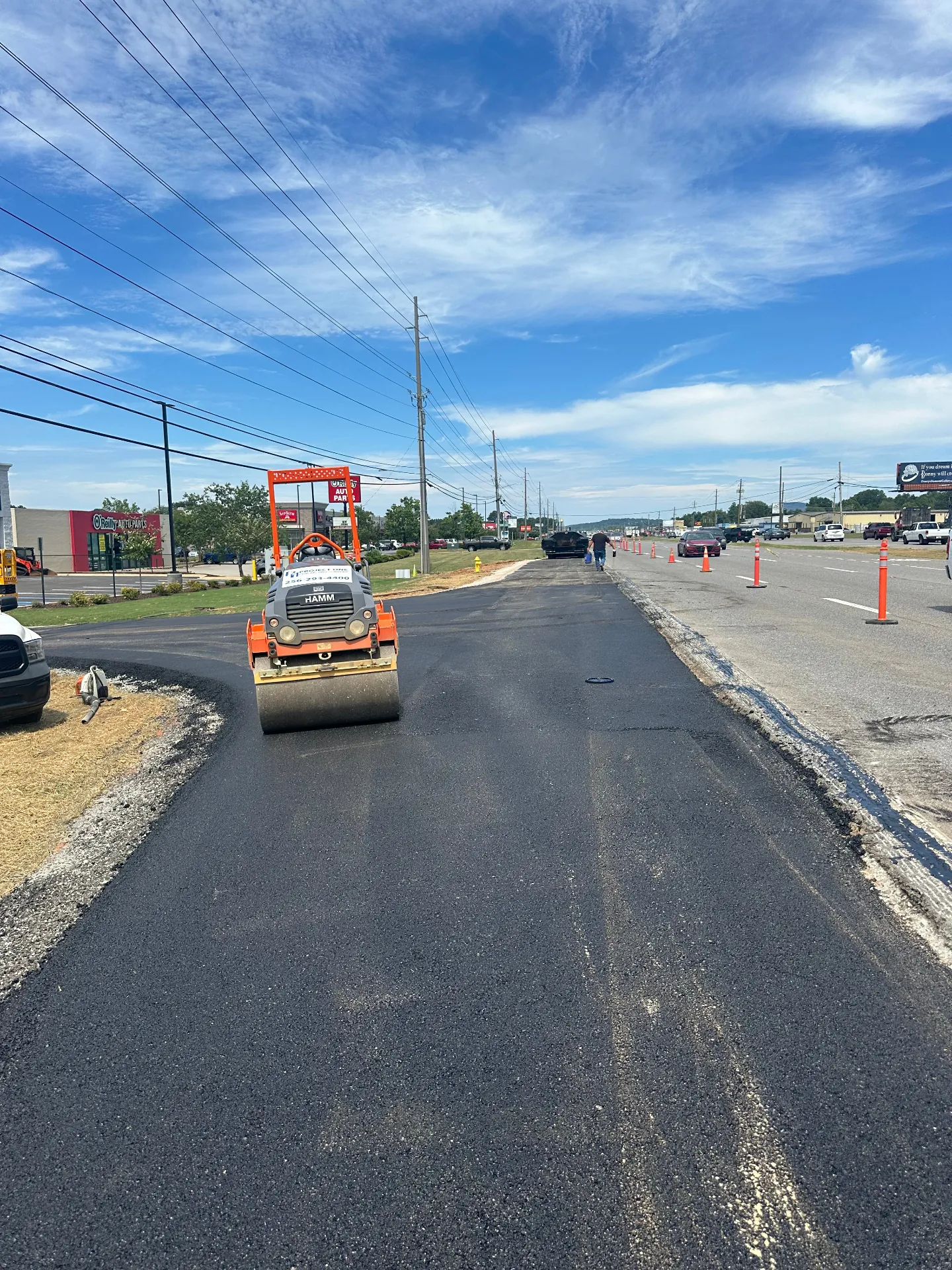 Hamm roller compacting a freshly paved commercial road