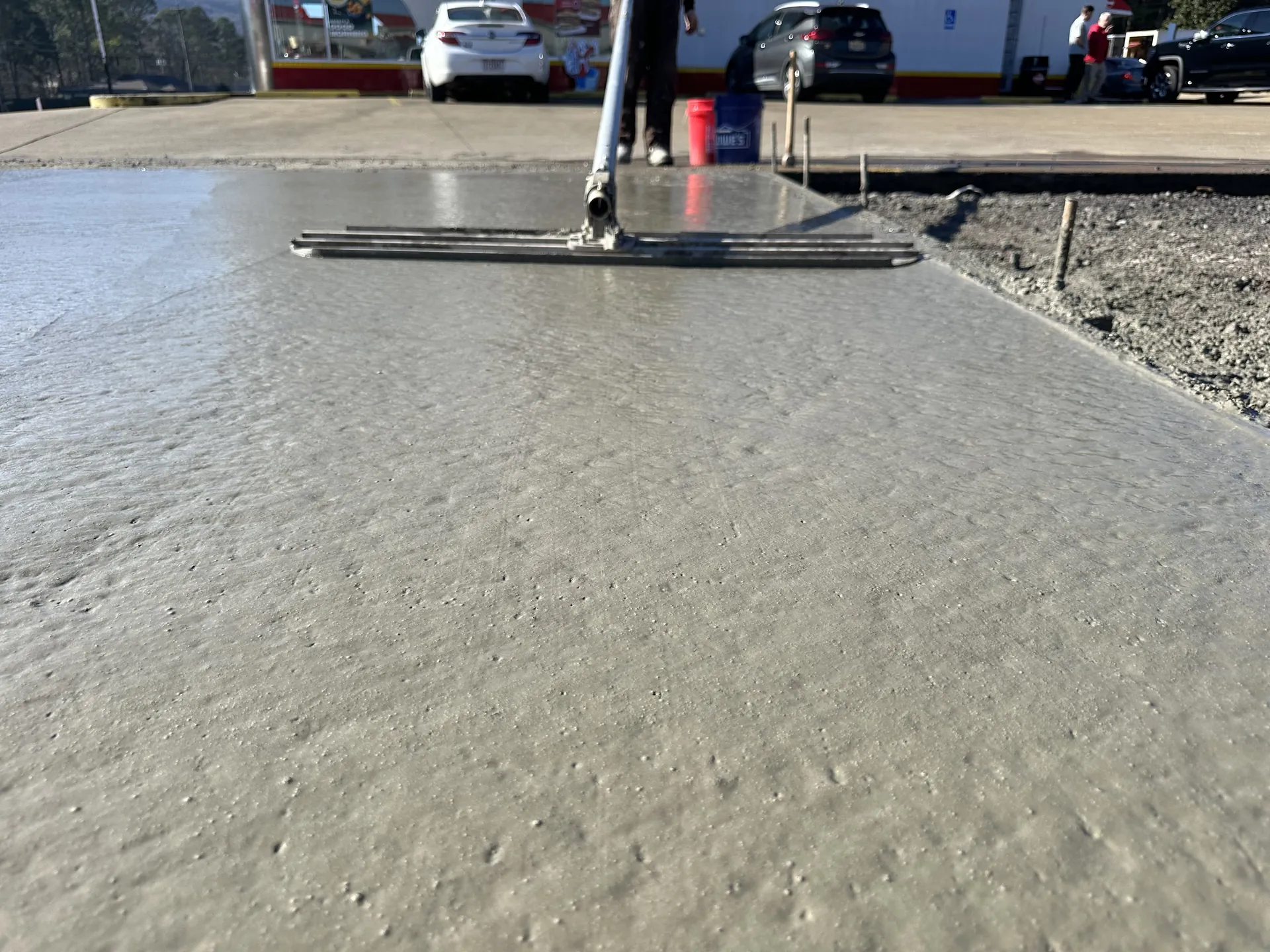 Crew bull-floating fresh concrete pour