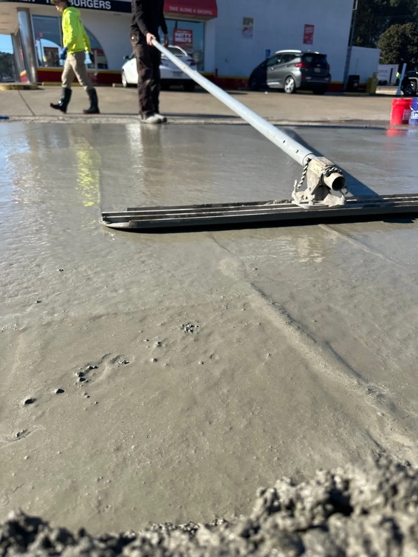Crew bull-floating a freshly poured concrete slab