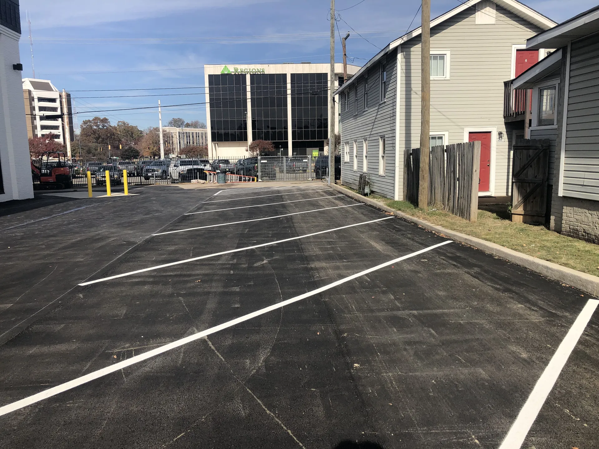 Freshly striped downtown parking lot with crisp white stalls near Regions building by Project One Contracting
